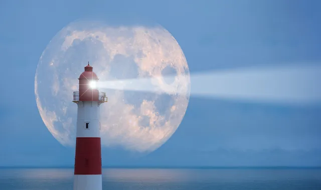 euchtturm vor dem Meer, im Hintergrund ein großer Vollmond, dessen Lichtstrahl vom Leuchtturm ausgeht.